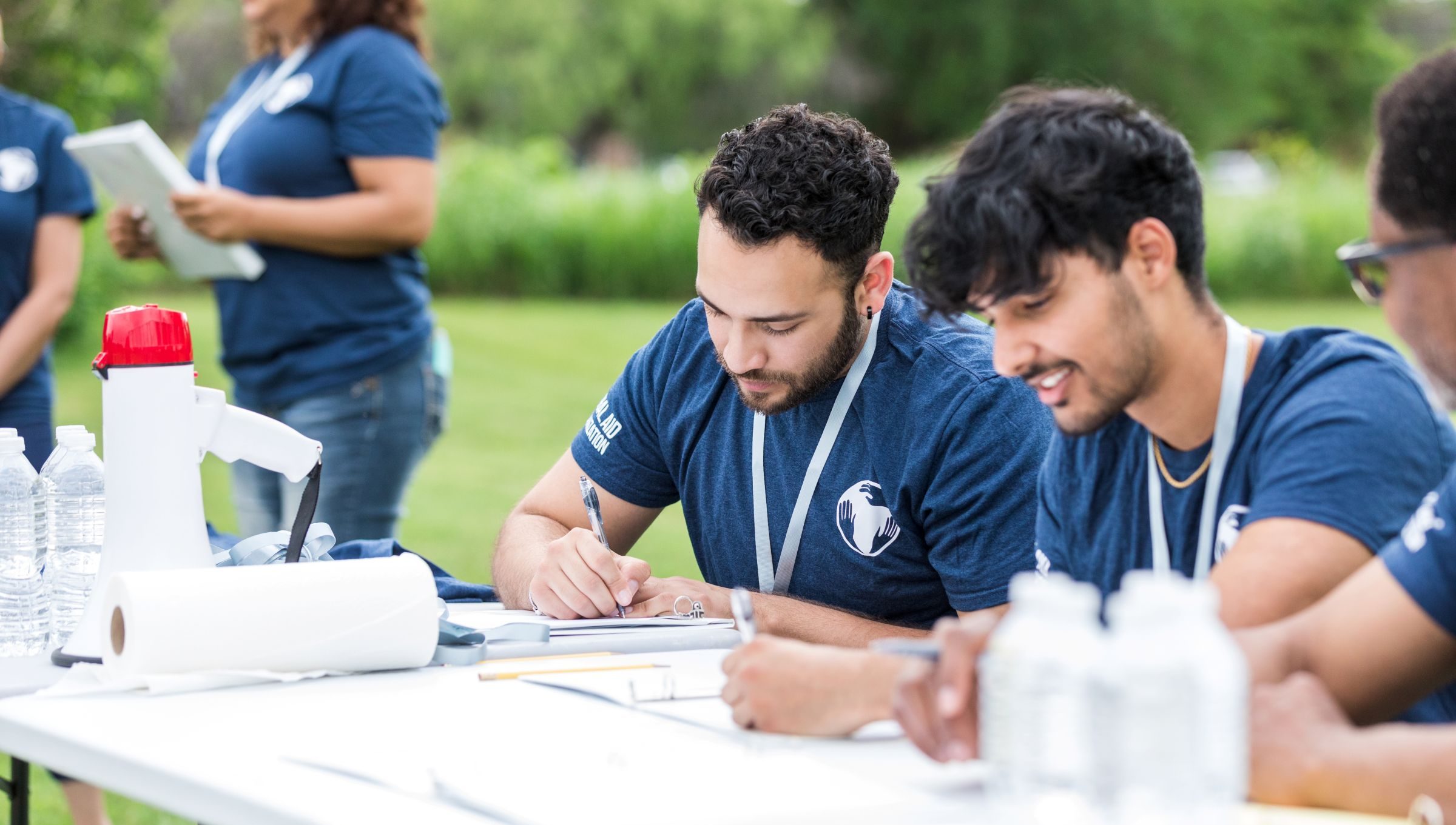 Photo of male students outdoors at a desk working in the field