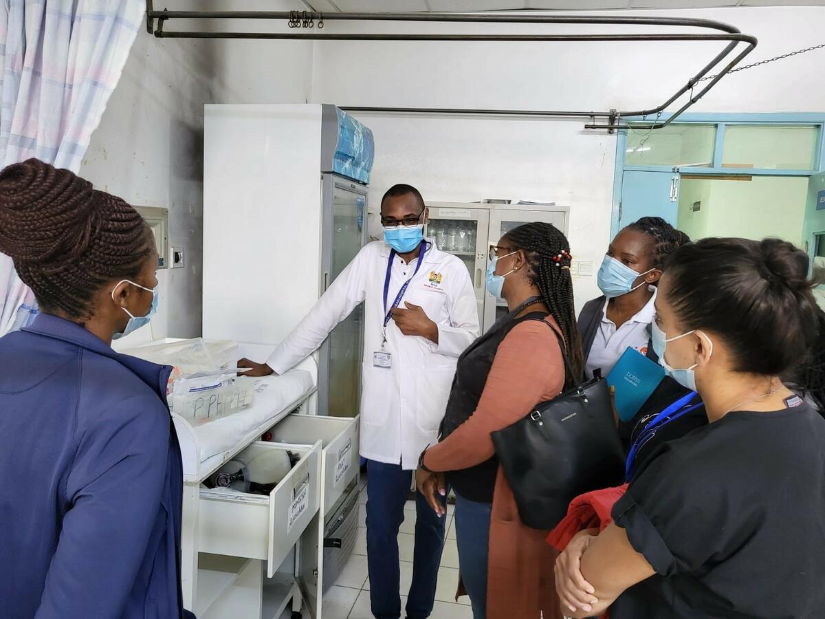 A photo of a group of maternal health studies students talking to a doctor on a hospital ward.