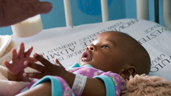 A photo of a small baby in a cot.