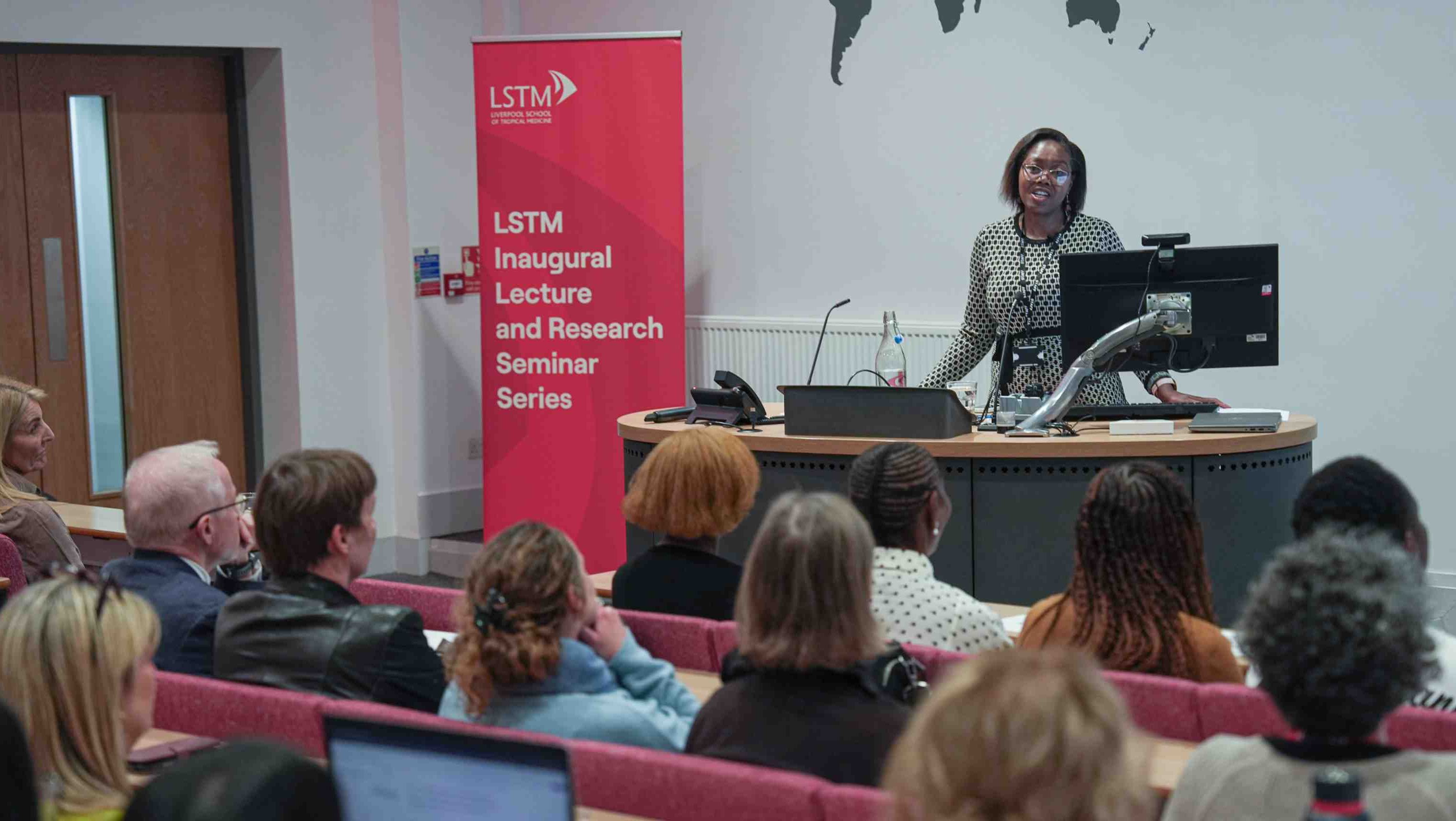 Speaker addresses an audience in a lecture theatre during the Liverpool School of Tropical Medicine Inaugural Lecture and Research Seminar Series.