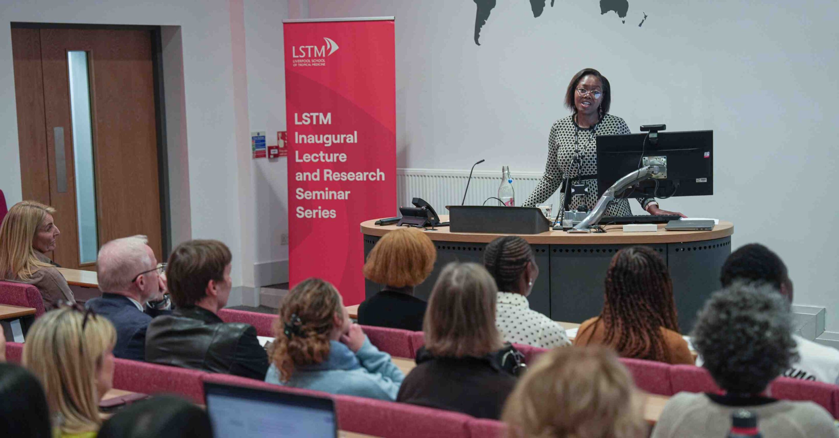 Speaker addresses an audience in a lecture theatre during the Liverpool School of Tropical Medicine Inaugural Lecture and Research Seminar Series.
